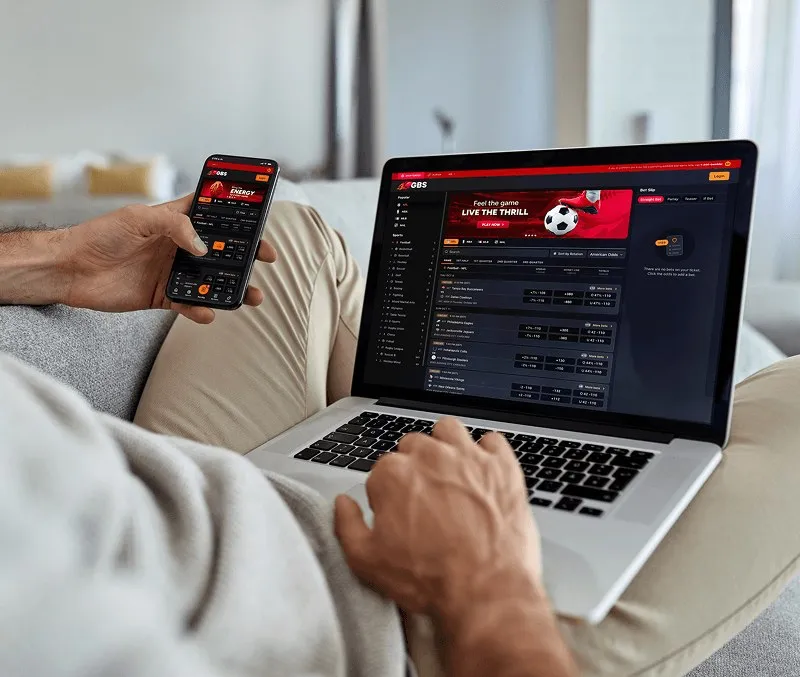 A bettor using the GBS sportsbook on a laptop and a phone
